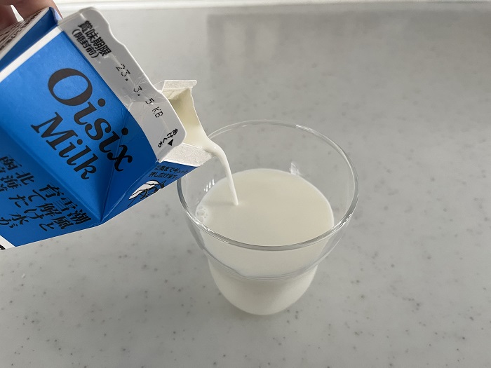 潮風と雪解け水が育てた北海道函館牛乳をコップに注ぐ